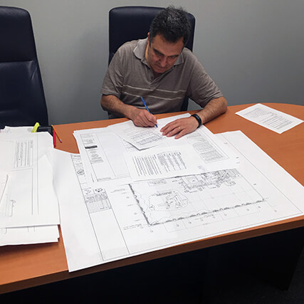 A view of an office lounge with large overhead lights and an HVAC unit in view.