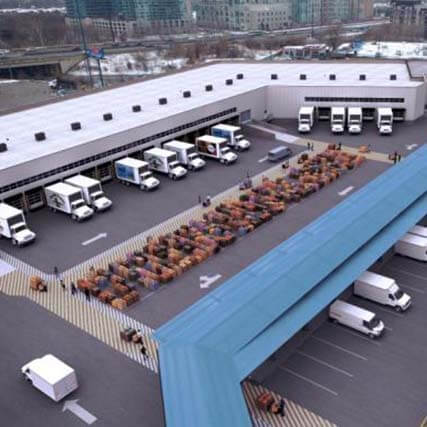 Birds eye view of several freight trucks parked at an industrial building.